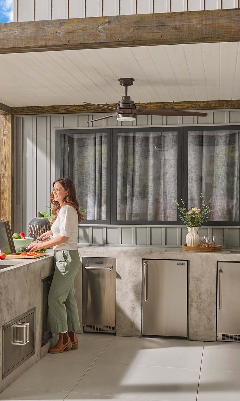 Woman in outdoor kitchen with fan above her
