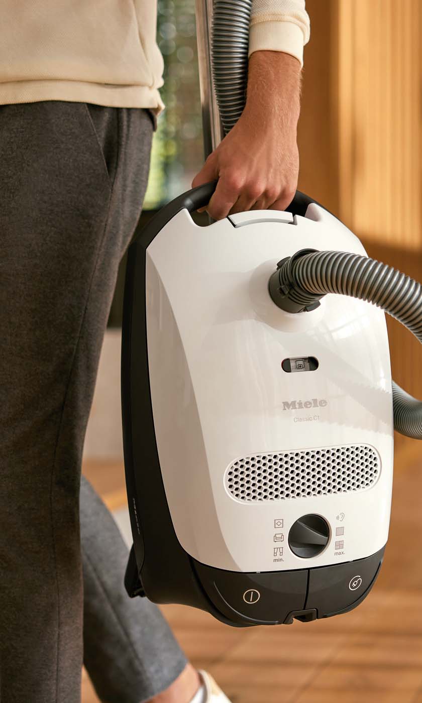 Woman plugging in a central vacuum to the wall