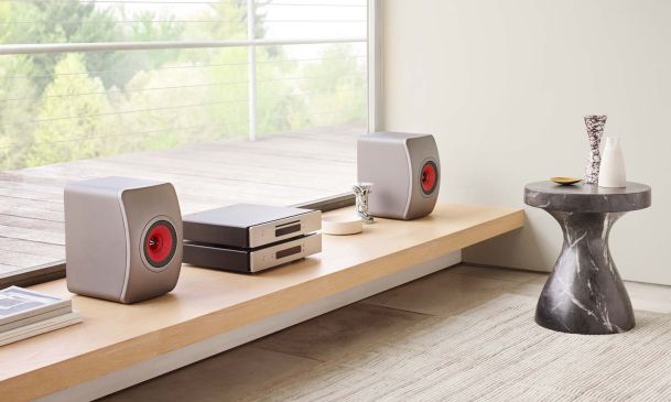 Kef bookshelf speakers on a light wood shelf